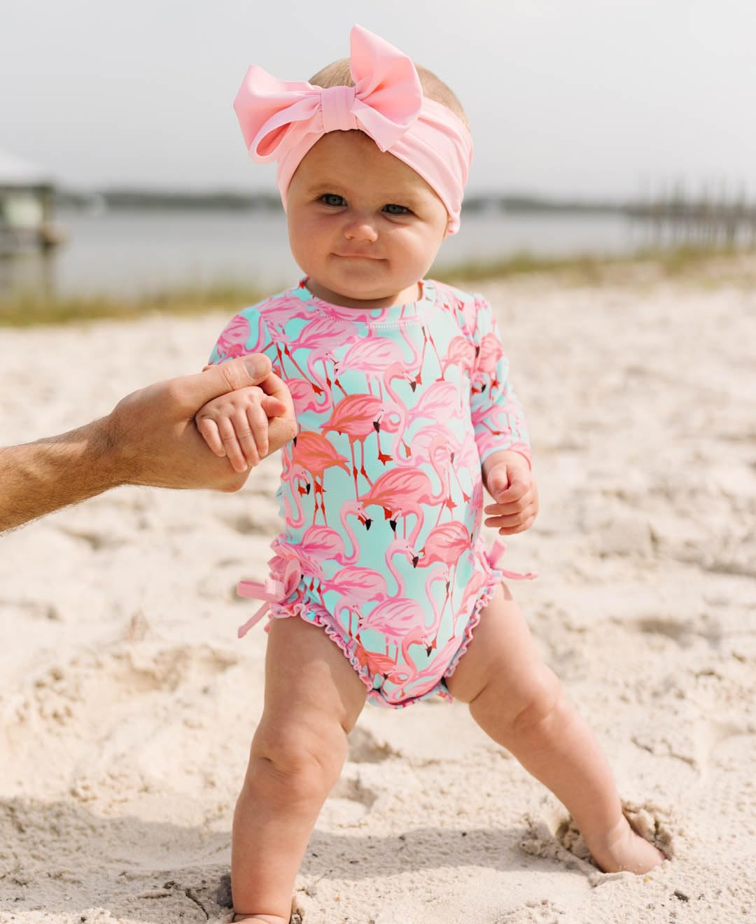RuffleButts Baby Girls UPF 50+ Sun Protection Tropical Print Long Sleeve One Piece Rash Guard Swimsuit with Zipper - Fab Flamingo, 3-6m